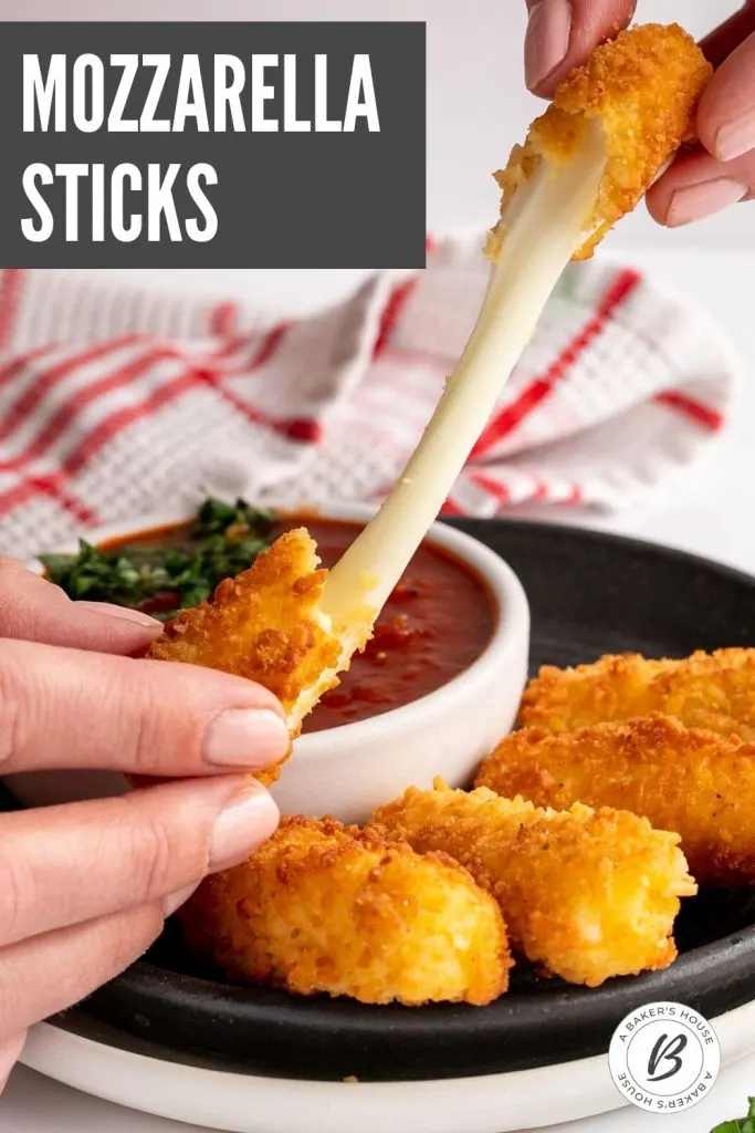 gooey mozzarella sticks pulled apart by two hands