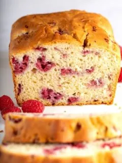 raspberry bread cut in half on white surface