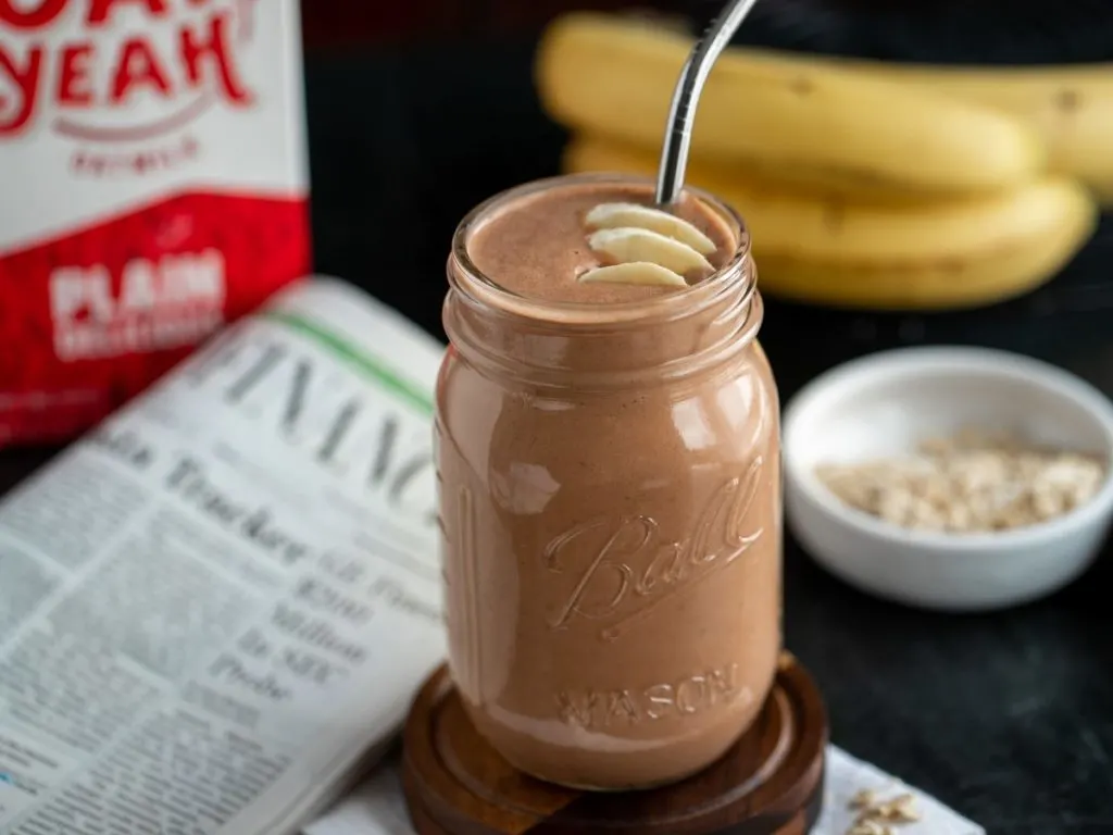 chocolate smoothie next to newspaper and Oat Yeah drink