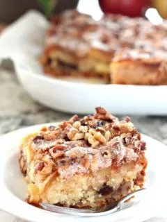 large slice of apple matzo cake with walnuts and sugar on white plate