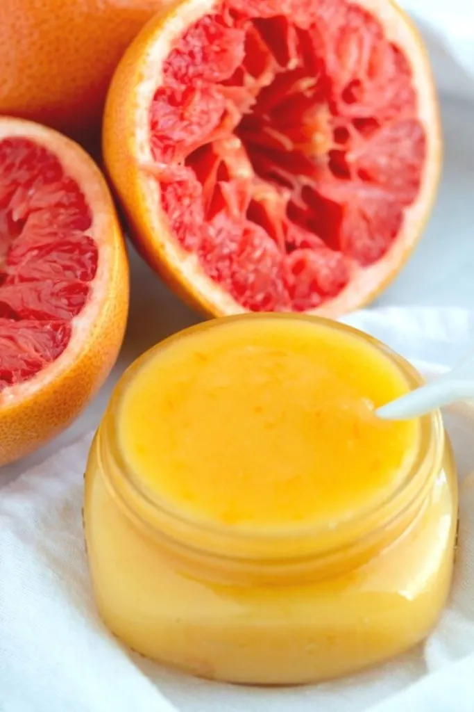 overhead view of mason jar filled with grapefruit curd with fresh fruit next to the jar