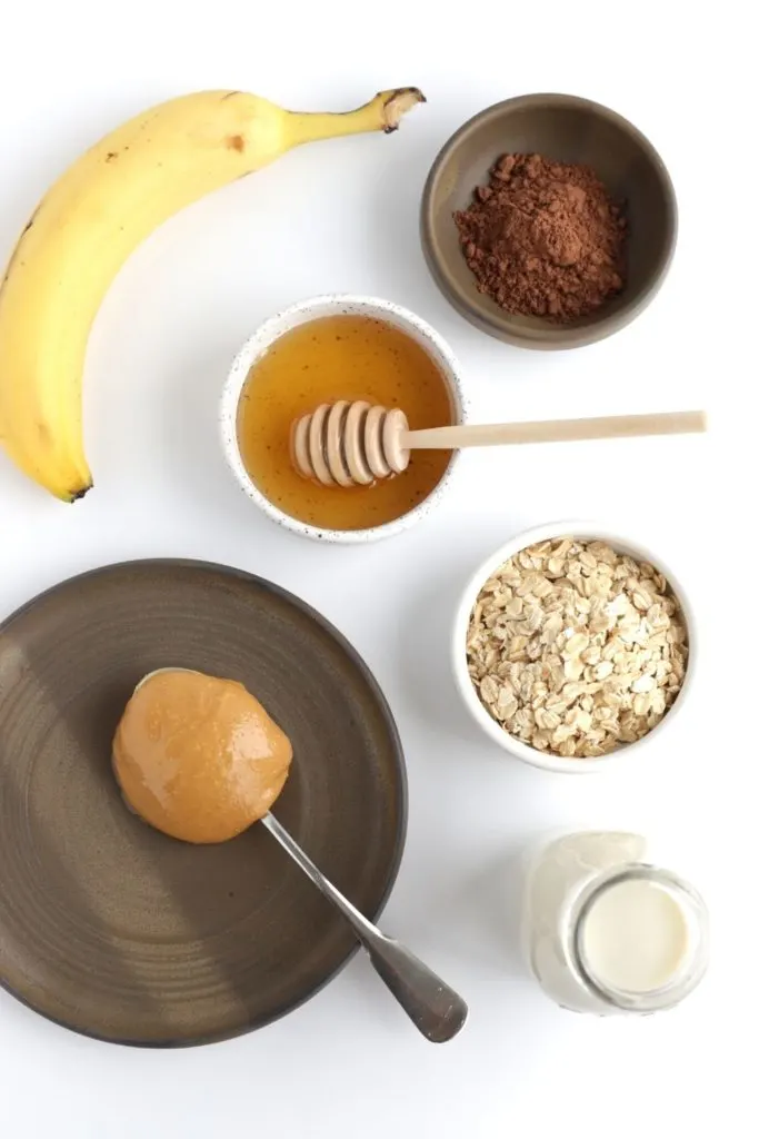 Ingredients for a chocolate peanut butter smoothie on white surface