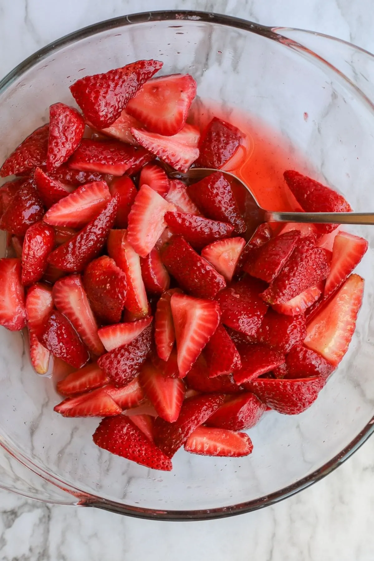 bowl of red strawberries in strawberry syrup as a result of macerating