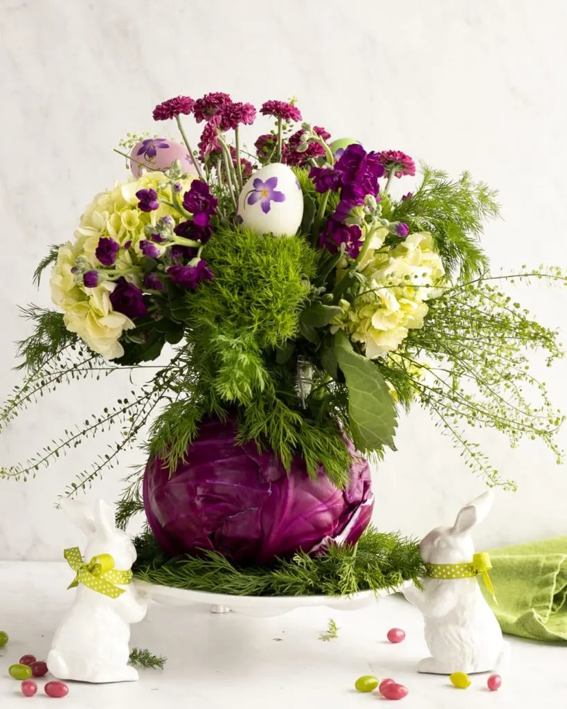 Easter centerpiece with purple, pink and white flowers in a cabbage base