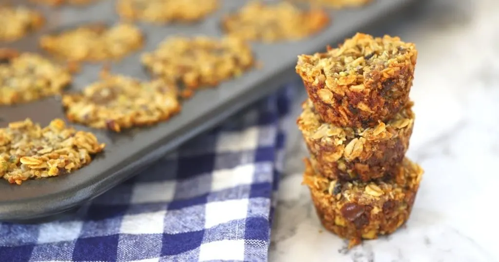 Baked aussie oat bites fresh out of the oven. three stacked with tray aside