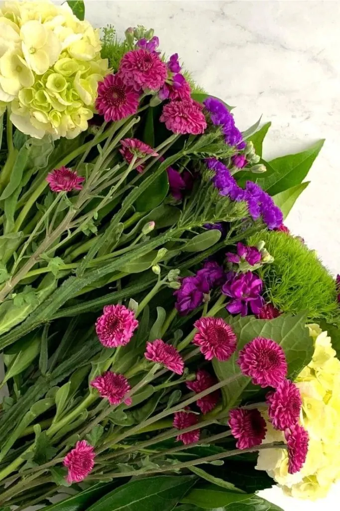 fresh flowers in white, purple, and pink on marble surface