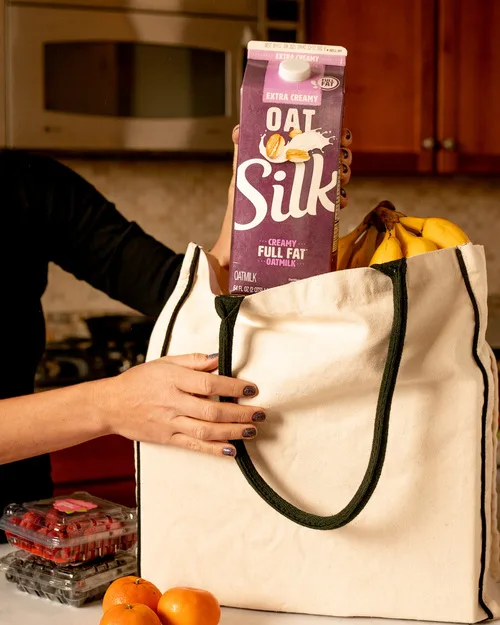 Silk Extra Creamy Oatmilk carton in a grocery bag