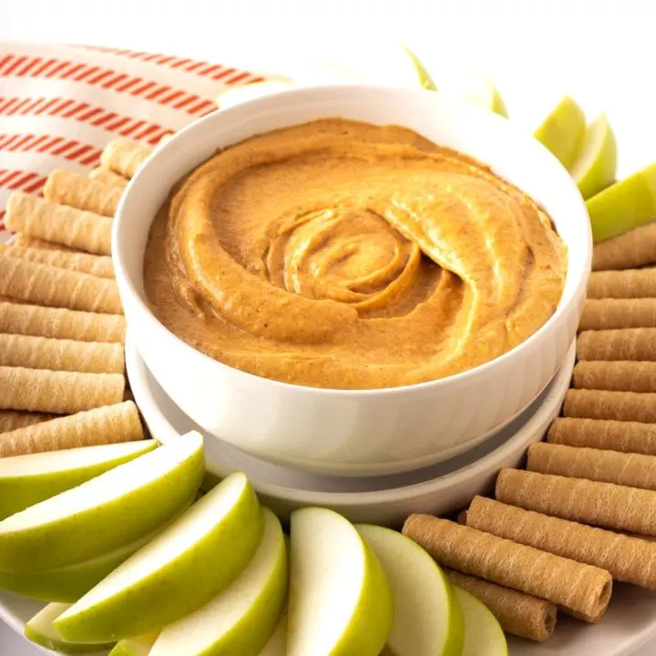 cream cheese pumpkin dip in white bowl with dippers