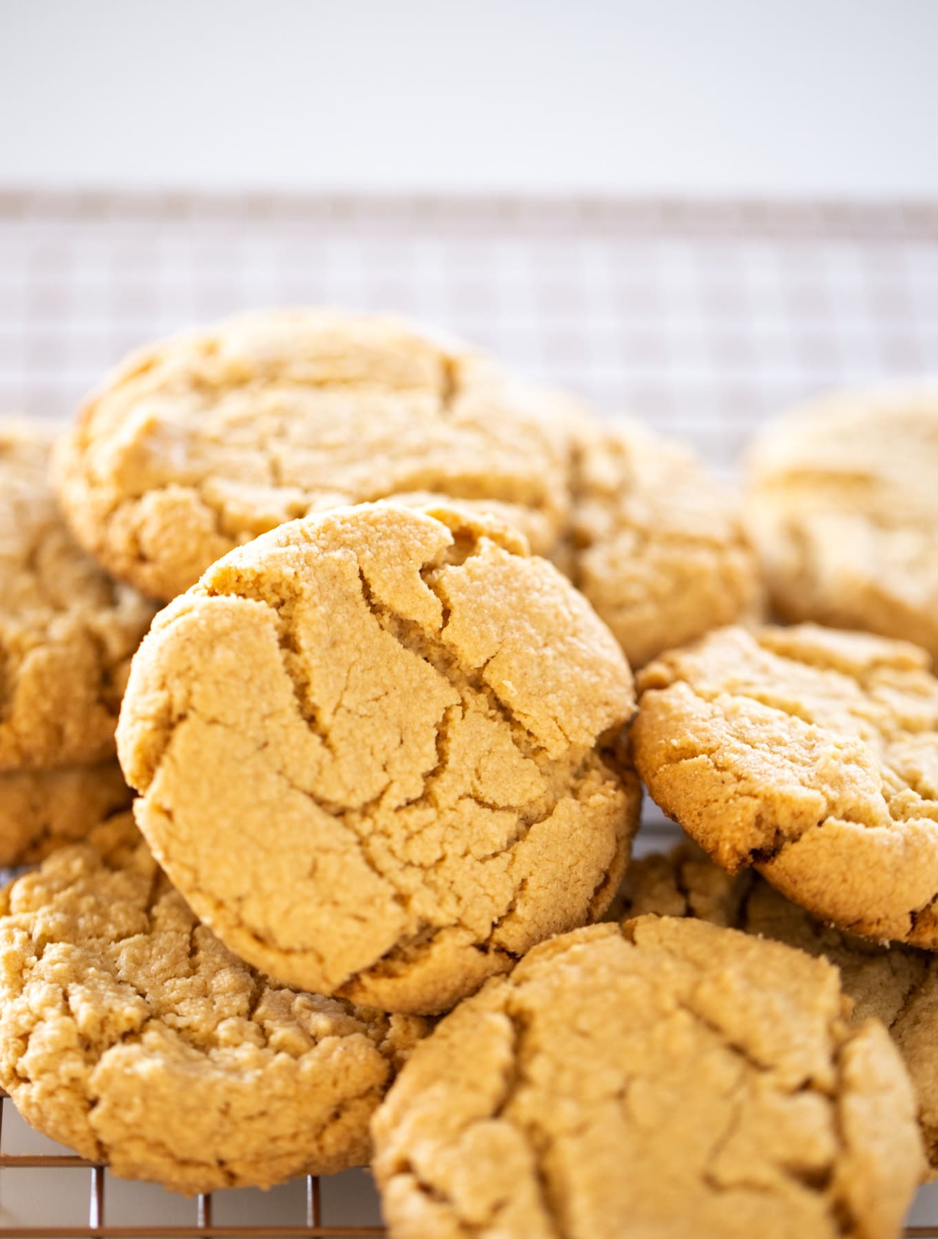 pile of peanut butter cookies on wire cooling rack